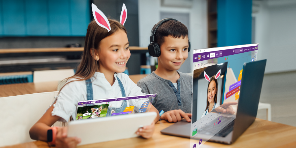 Two children with bunny ears filter on their headphones, learning coding on laptops in a classroom 
