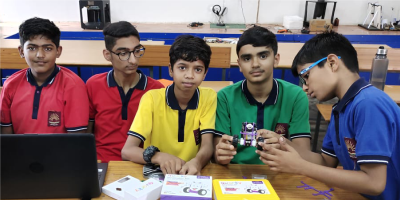 A group of students working together on a Quarky robotics kit in a PM Shri Tinkering lab, fostering teamwork and technical skills