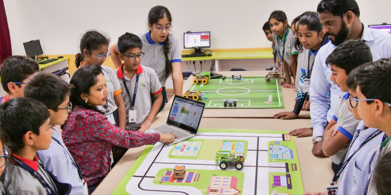 Teacher demonstrating practical AI and robotics applications to students